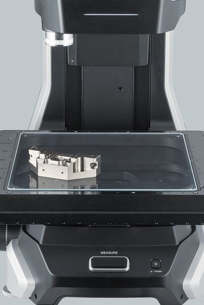 A milled metal housing with several square ports, resting on the stage.