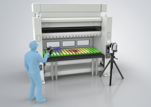 A worker scans a machine with a handheld probe while the camera stands on a tripod.