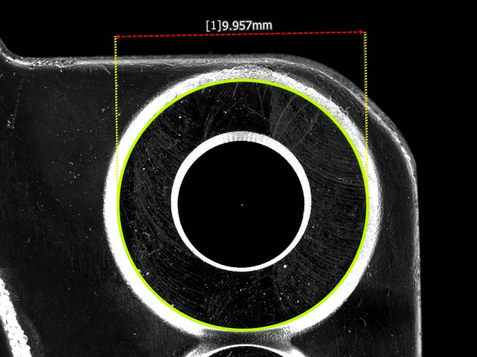 The hole automatically measured and fitted with a green circle, with the result displayed: 9.957mm.